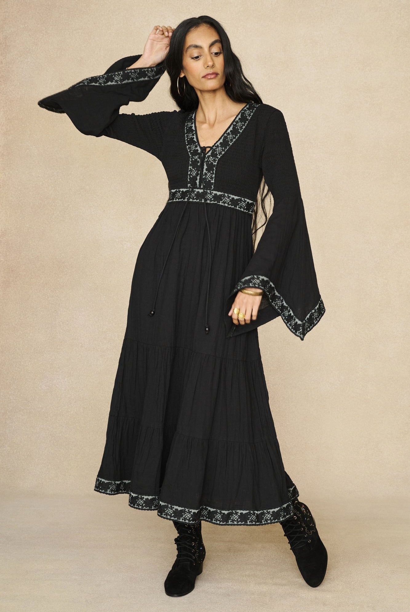 Model wearing 70s black long sleeve maxi dress with lace-up Penny Lane boots by The Hippie Shake, front view