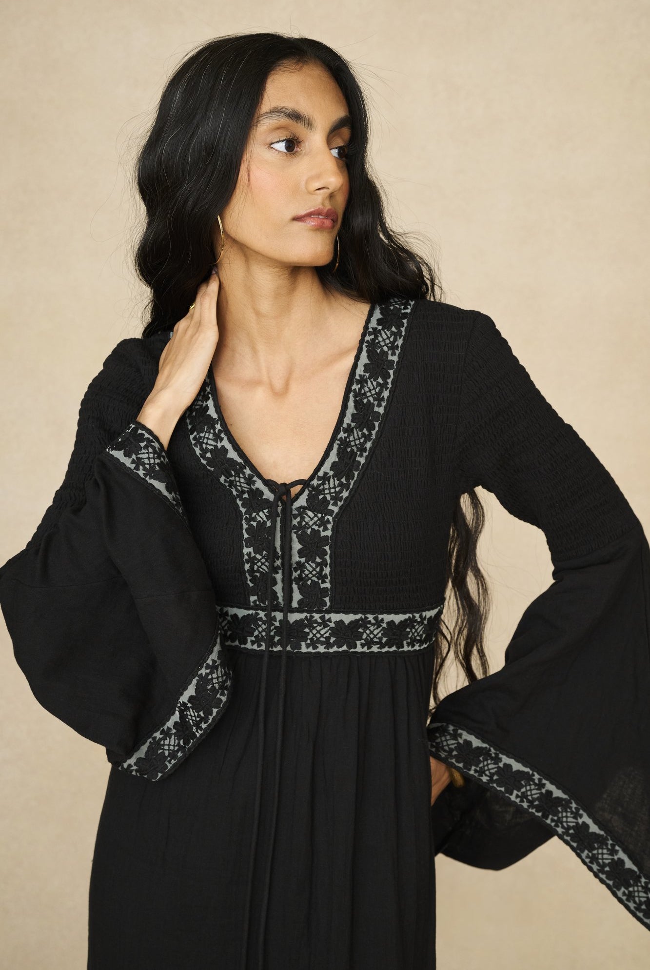 Model wearing 70s black long sleeve maxi dress with lace-up Penny Lane boots by The Hippie Shake, close up