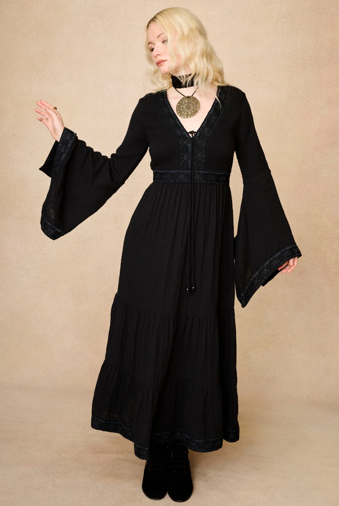 Model wearing 70s black long sleeve maxi dress with lace-up Penny Lane boots by The Hippie Shake, front view