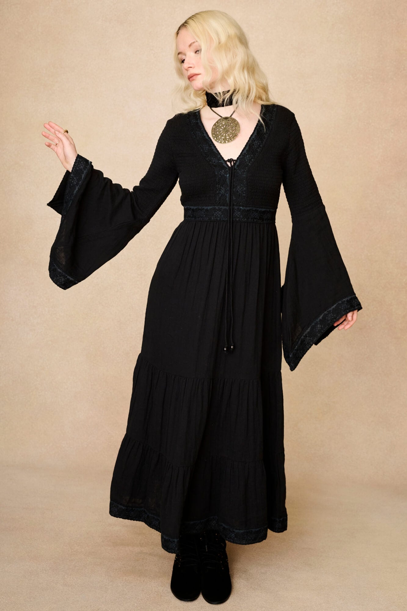 Model wearing 70s black long sleeve maxi dress with lace-up Penny Lane boots by The Hippie Shake, front view