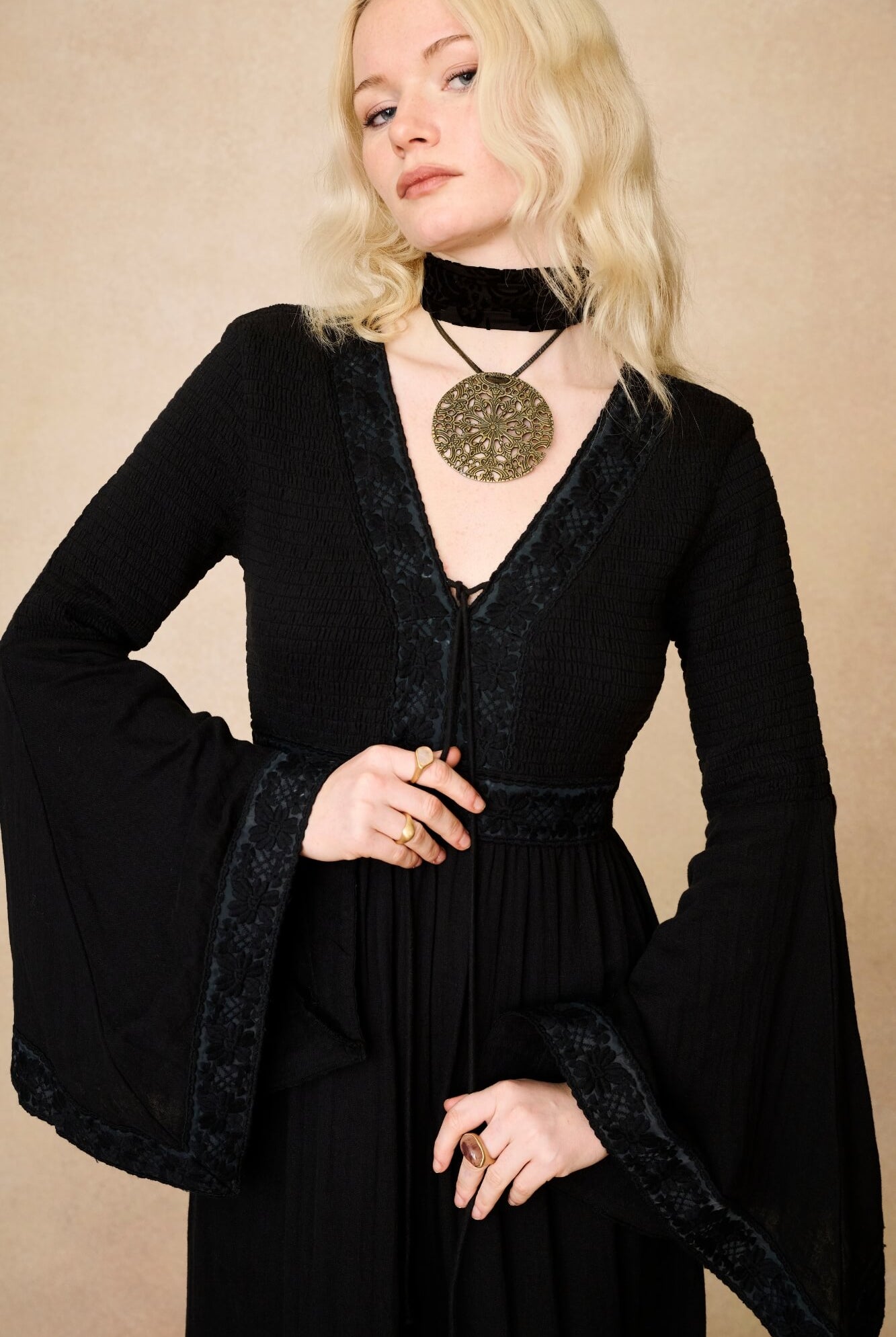 Model wearing 70s black long sleeve maxi dress with lace-up Penny Lane boots by The Hippie Shake, close up view