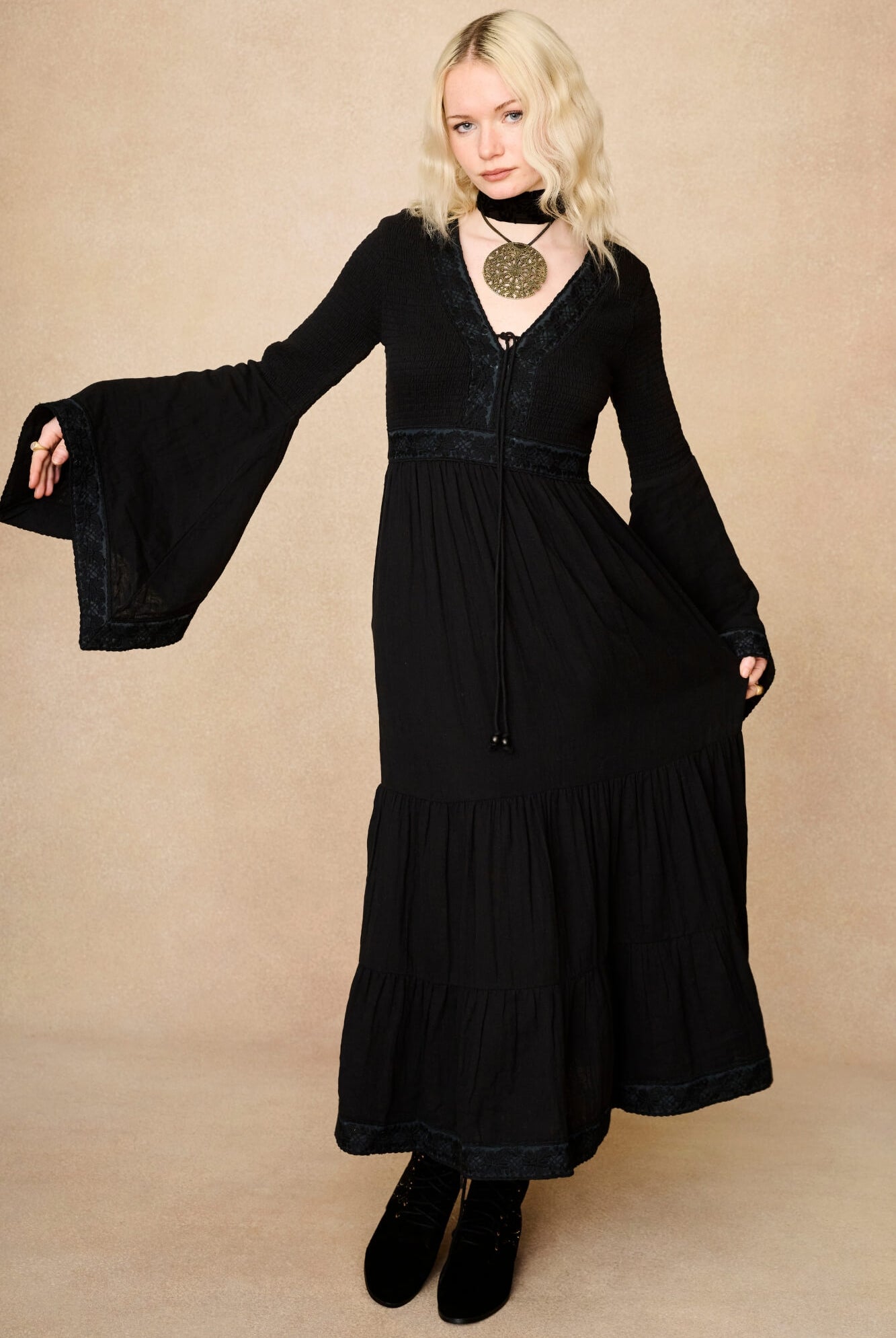 Model wearing 70s black long sleeve maxi dress with lace-up Penny Lane boots by The Hippie Shake, front view