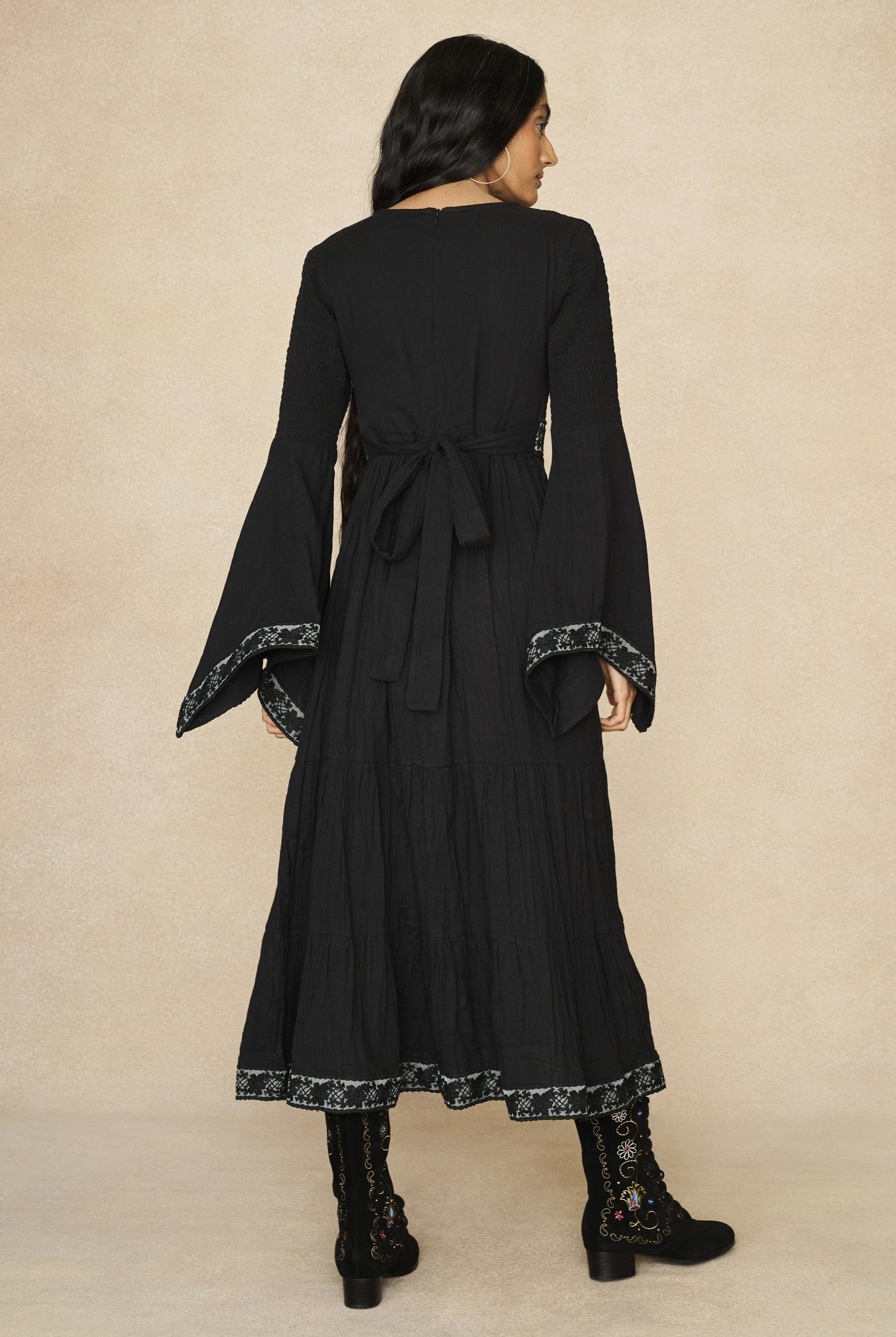 Model wearing 70s black long sleeve maxi dress with lace-up Penny Lane boots by The Hippie Shake, back view