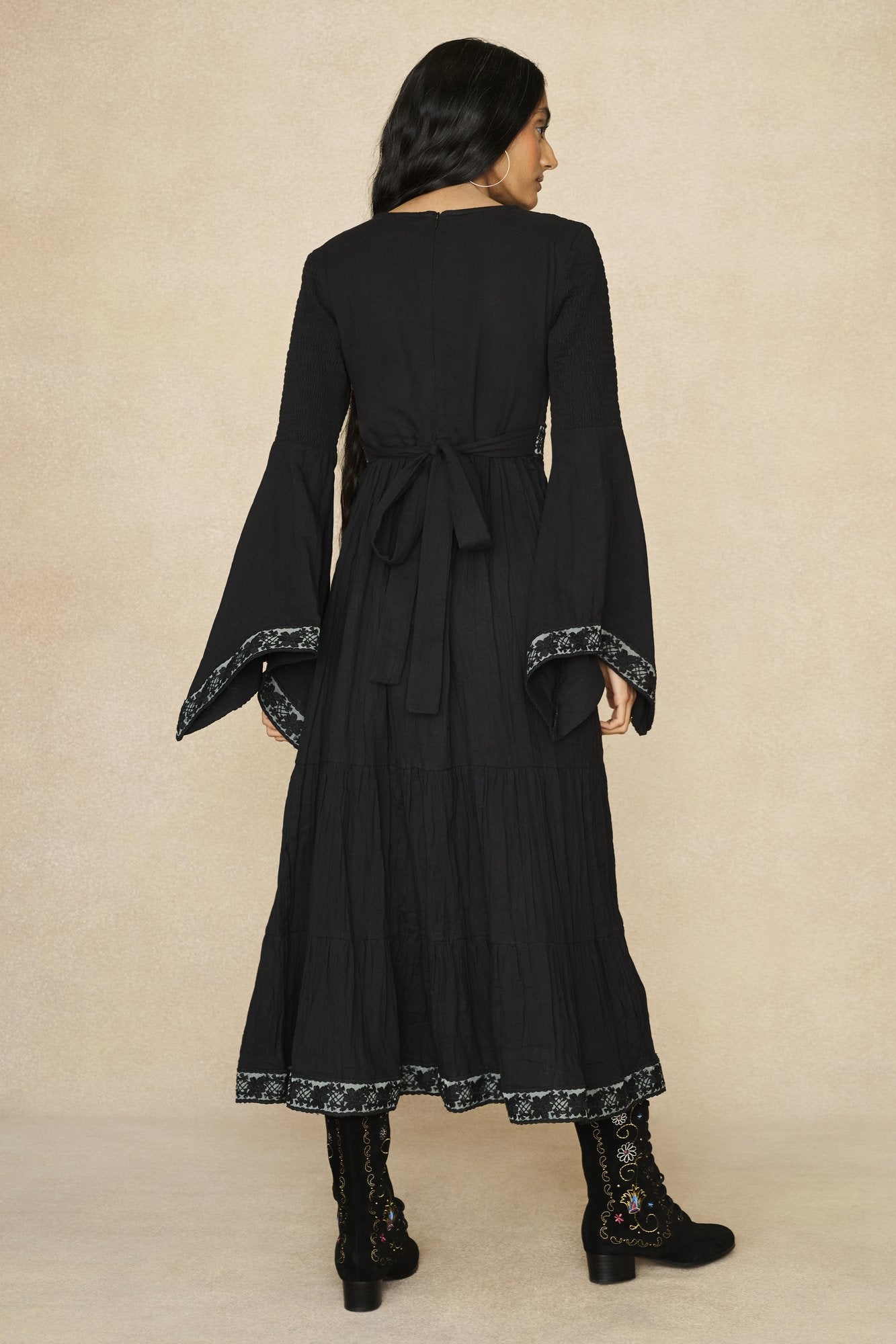 Model wearing 70s black long sleeve maxi dress with lace-up Penny Lane boots by The Hippie Shake, back view