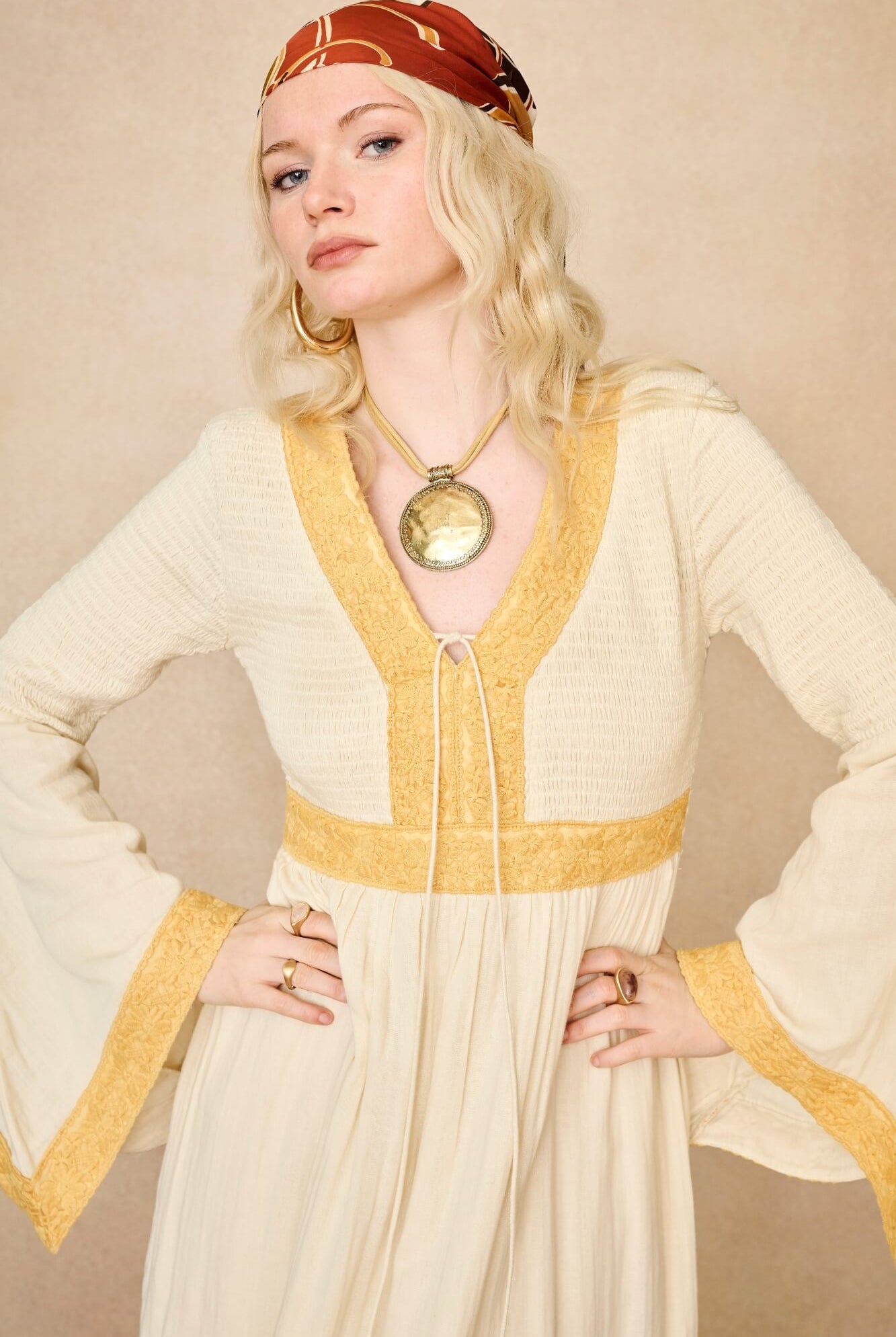 Model wearing 70s cream long sleeve maxi dress with lace-up Penny Lane boots by The Hippie Shake, close up view