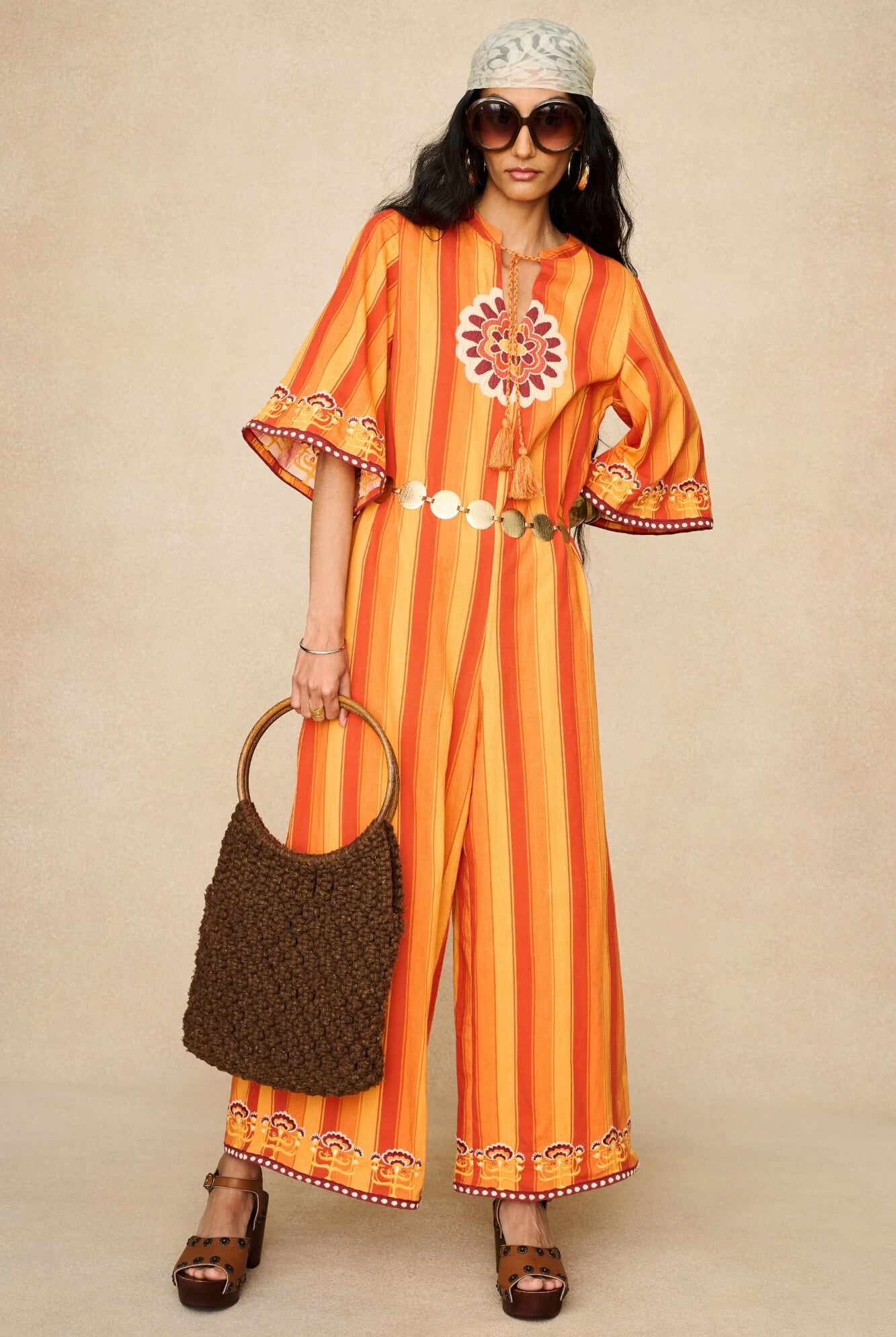Model wearing 70s orange striped wide leg jumpsuit by The Hippie Shake, front view