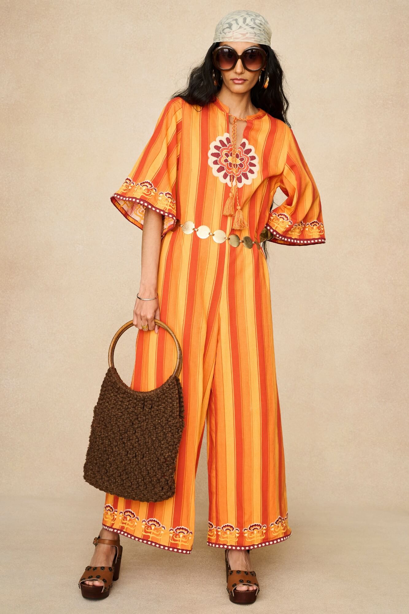 Model wearing 70s orange striped wide leg jumpsuit by The Hippie Shake, front view