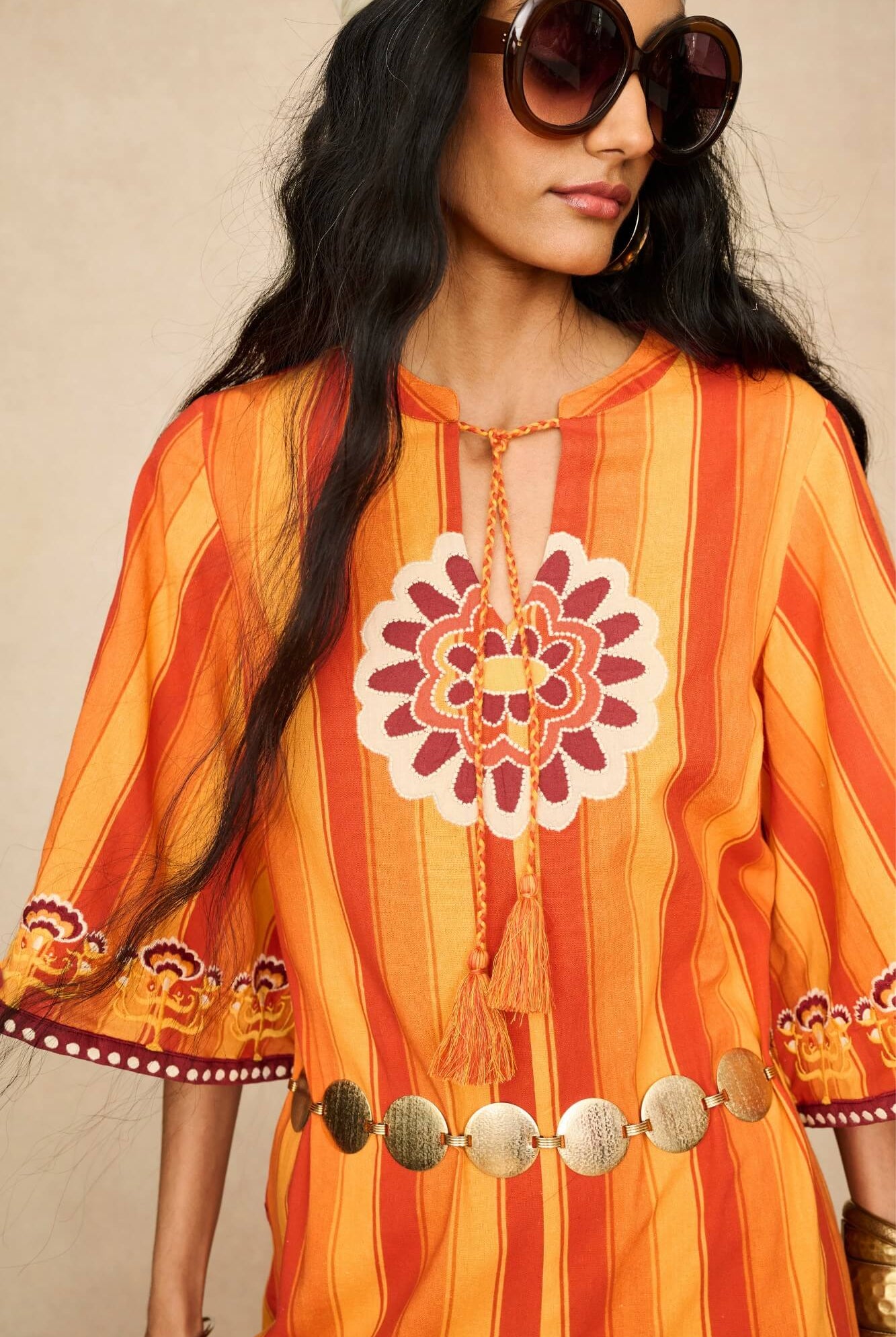 Model wearing 70s orange striped wide leg jumpsuit by The Hippie Shake, close up