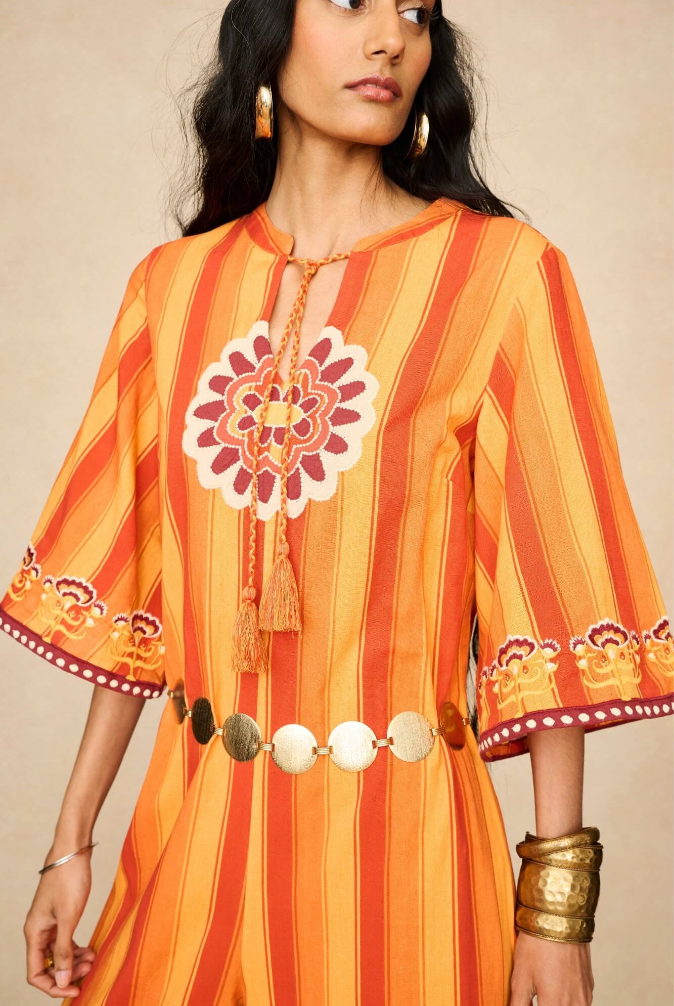 Model wearing 70s orange striped wide leg jumpsuit by The Hippie Shake, close up