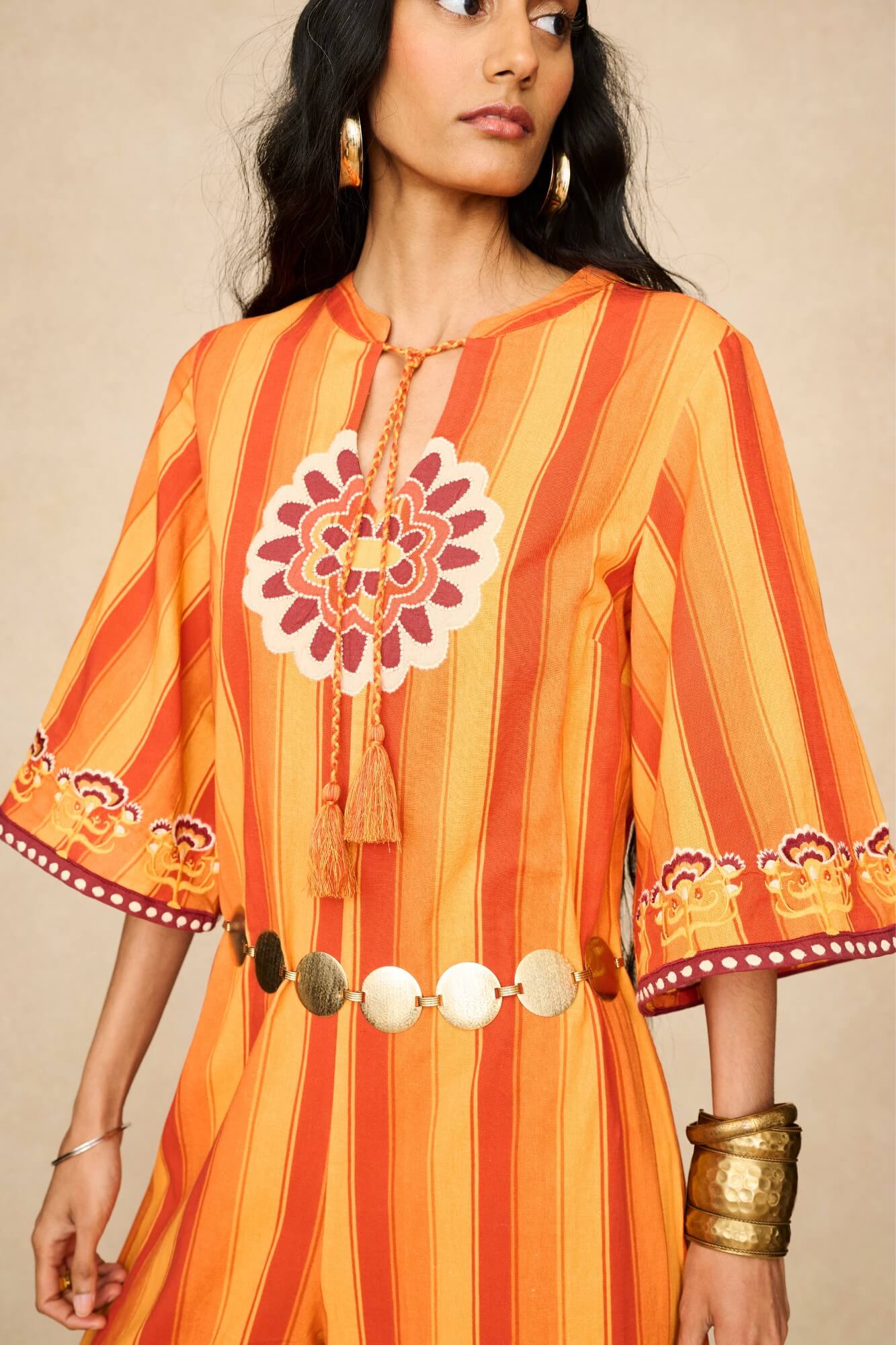 Model wearing 70s orange striped wide leg jumpsuit by The Hippie Shake, close up