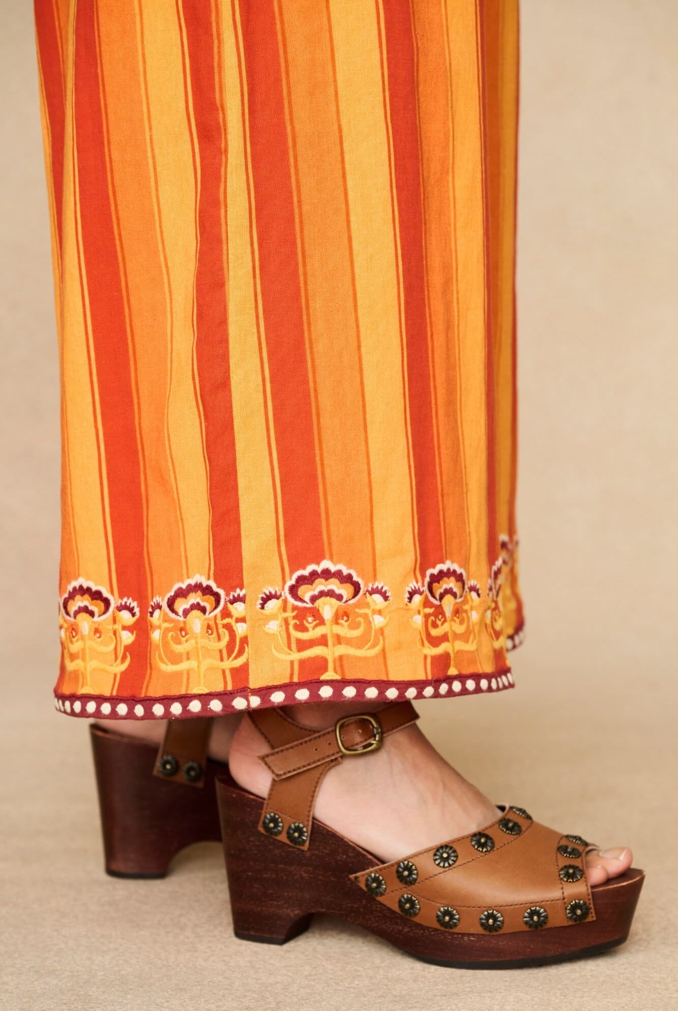 Model wearing 70s orange striped wide leg jumpsuit by The Hippie Shake, close up