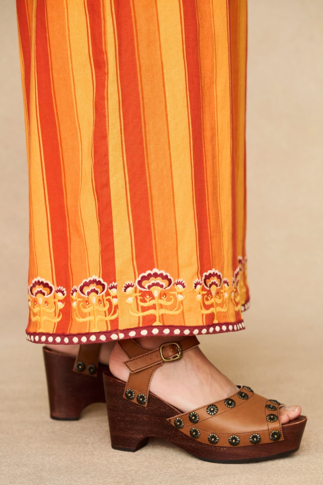 Model wearing 70s orange striped wide leg jumpsuit by The Hippie Shake, close up