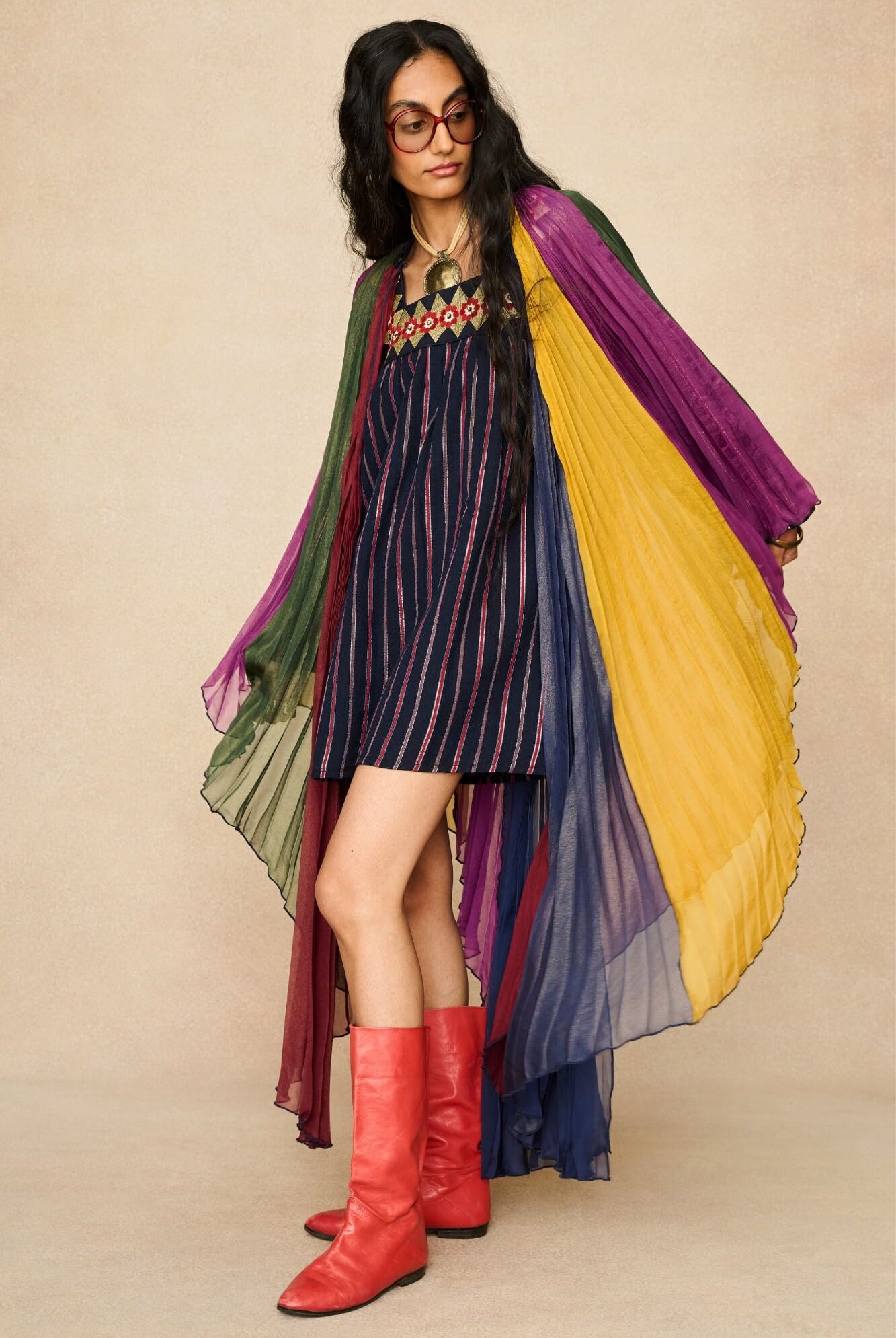 Model wearing 70s striped mini dress styled with a rainbow cape by The Hippie Shake, front view