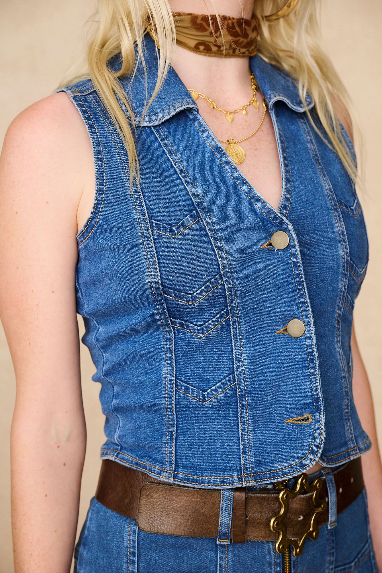 Close-up of The Hippie Shake's chevron denim waistcoat vest showing gold button detailing and vintage-inspired chevron stitching.