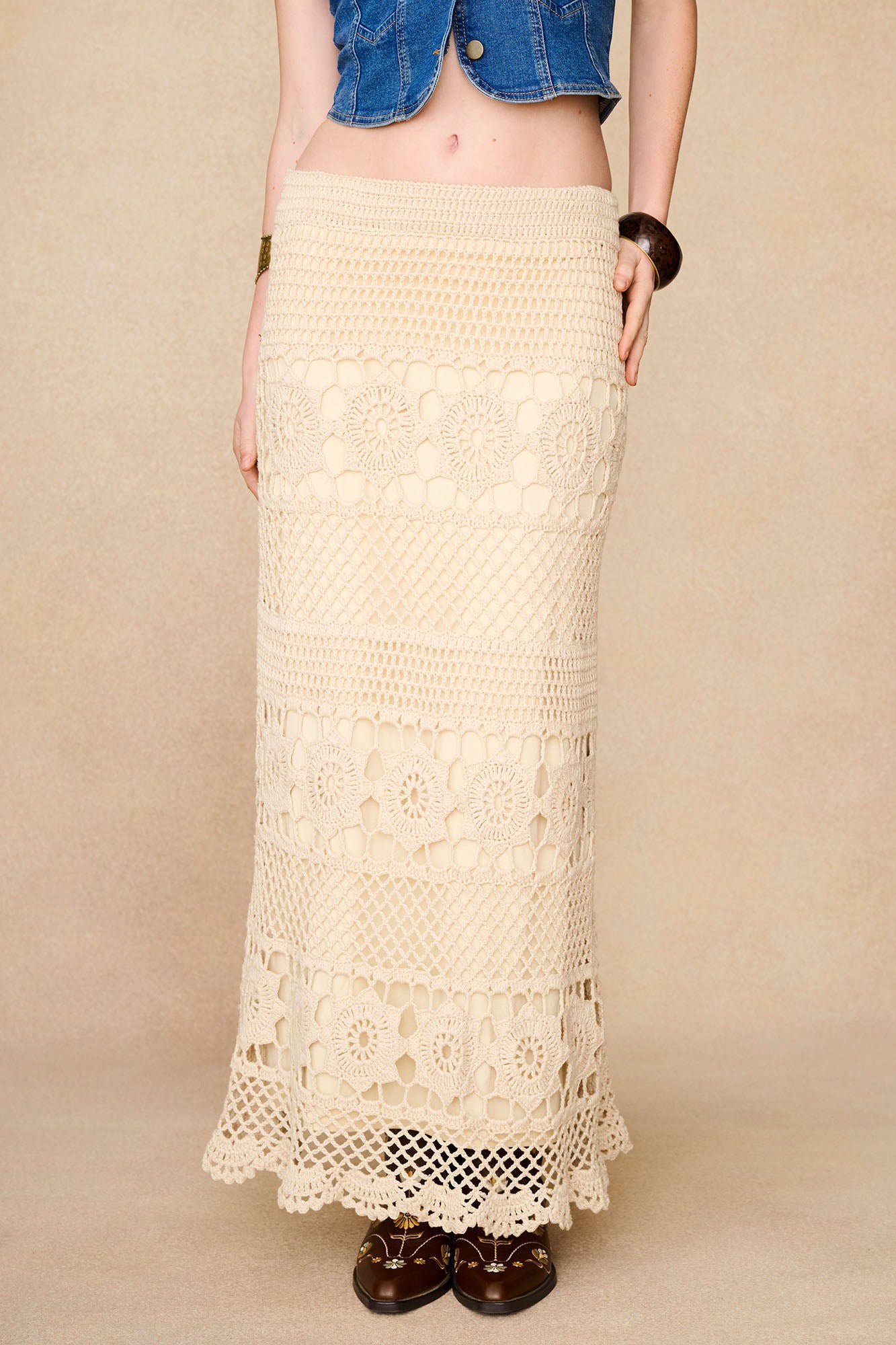 Close-up of The Hippie Shake's cream crochet maxi skirt showing its high waist and intricate crochet panels.