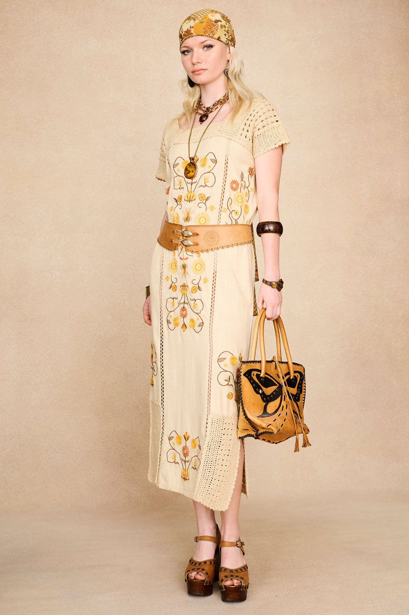 Full-length shot of The Hippie Shake's vintage style cream crochet trim midi dress styled with a statement belt.