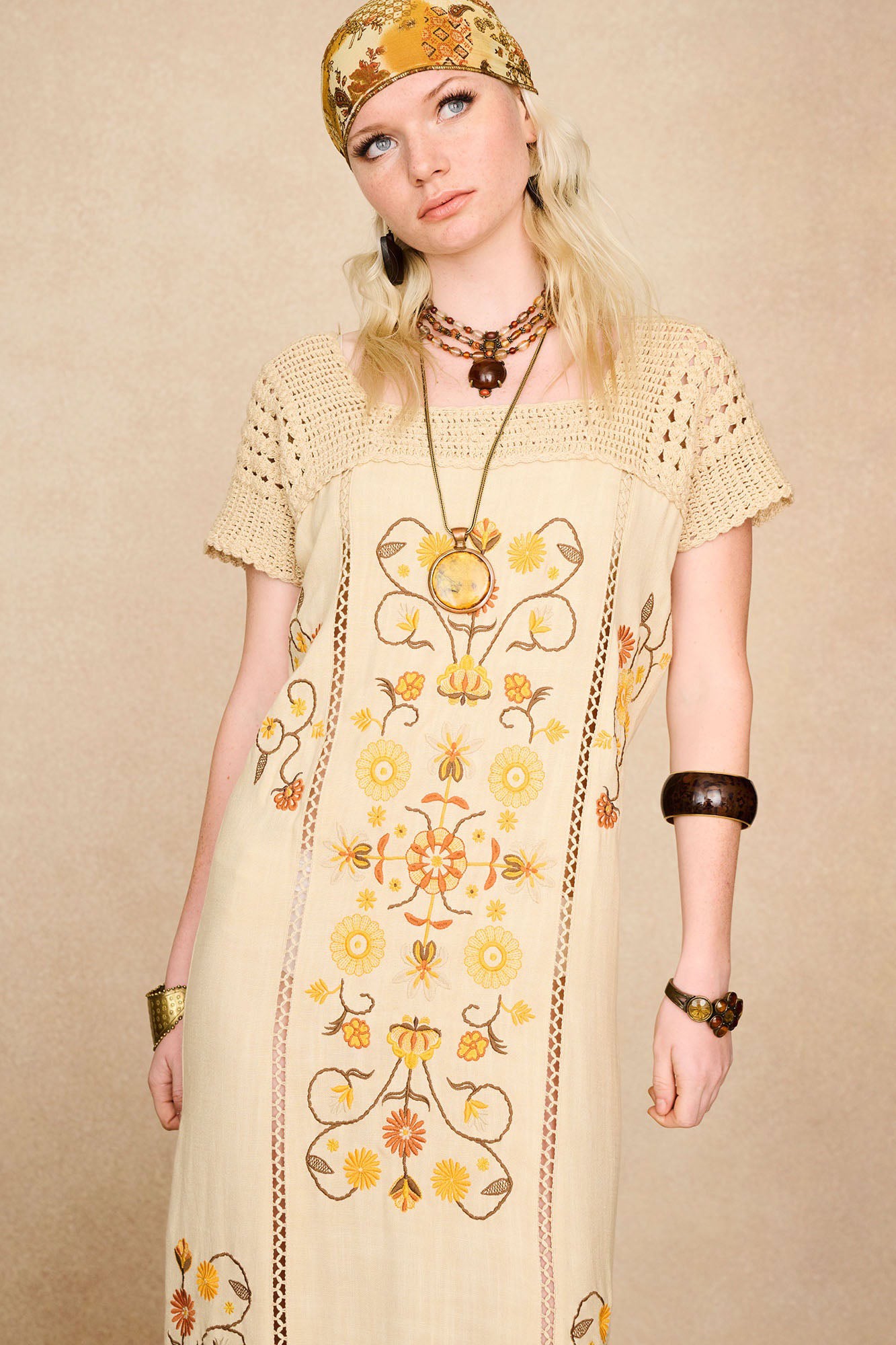 Model wearing The Hippie Shake's cream crochet embroidered midi dress, layered with a pendant necklace.