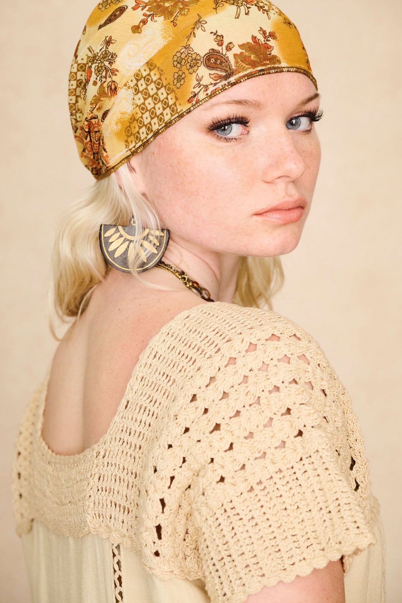 Close-up of The Hippie Shake's cream crochet embroidered midi dress, showing off the intricate crochet trim around the neckline. 
