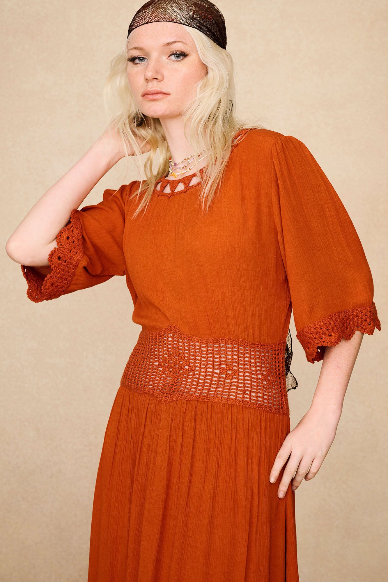 Close-up of the crochet embroidered waistband and sleeves on The Hippie Shake's orange crochet midi dress.