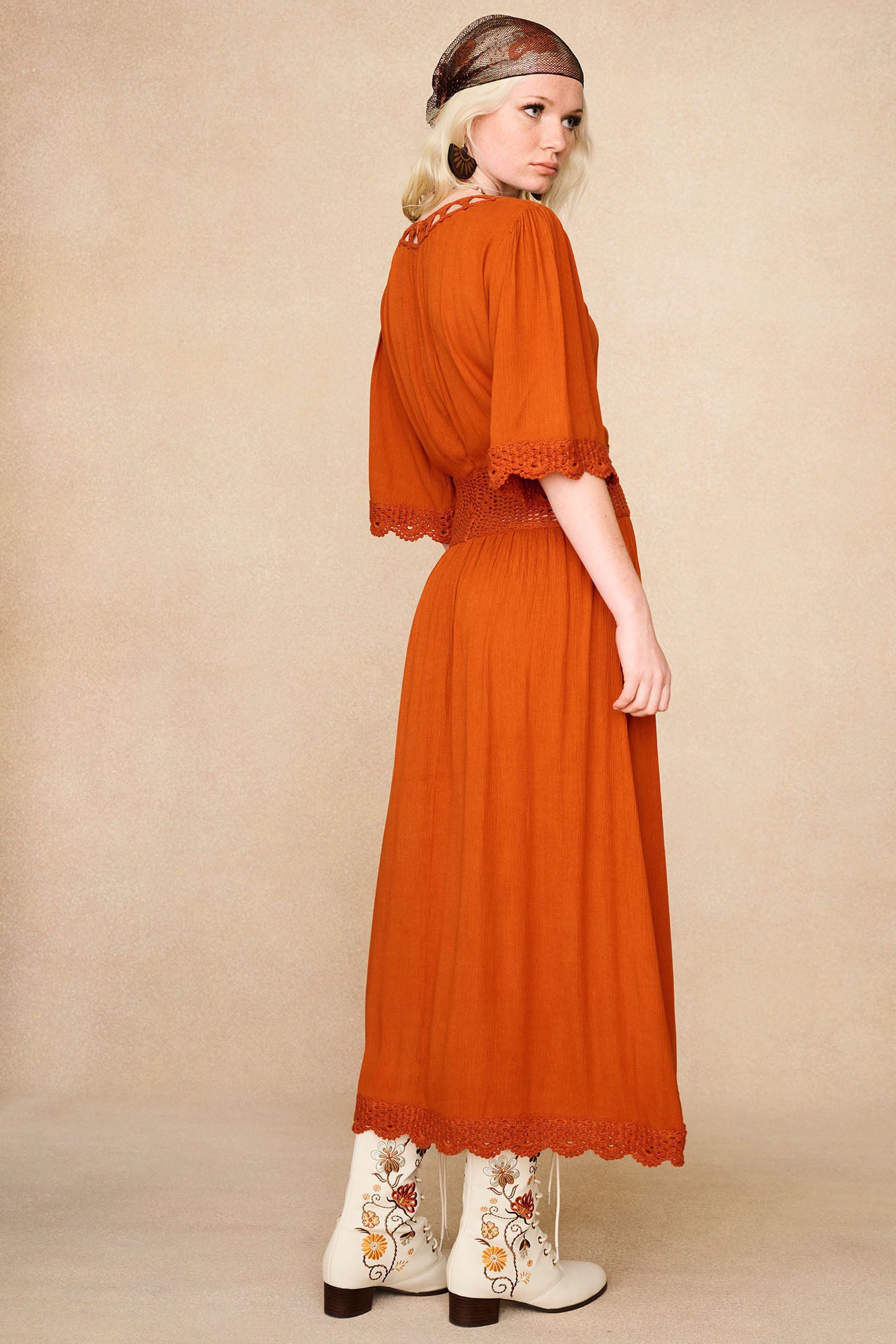 Back angle of The Hippie Shake's cream lace up Penny Lane boots paired with the orange crochet midi dress.