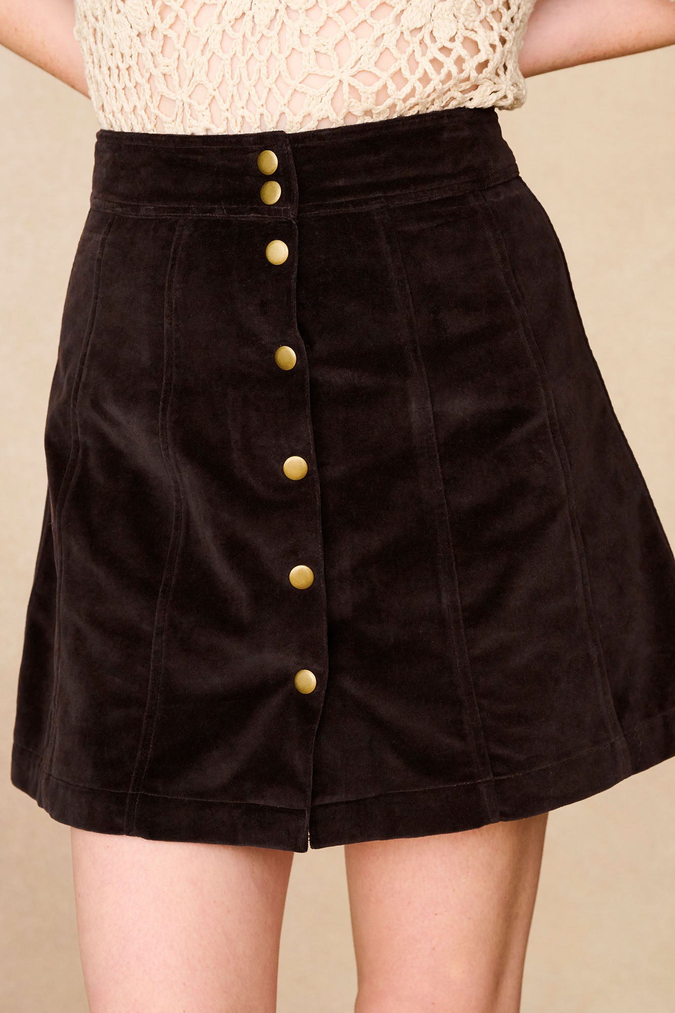 Close-up of The Hippie Shake's brown velvet mini skirt showing front button details.
