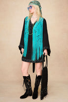 Model wearing The Hippie Shake's black mini dress with lace trim styled with our black embroidered boots and a blue tassel waistcoat.