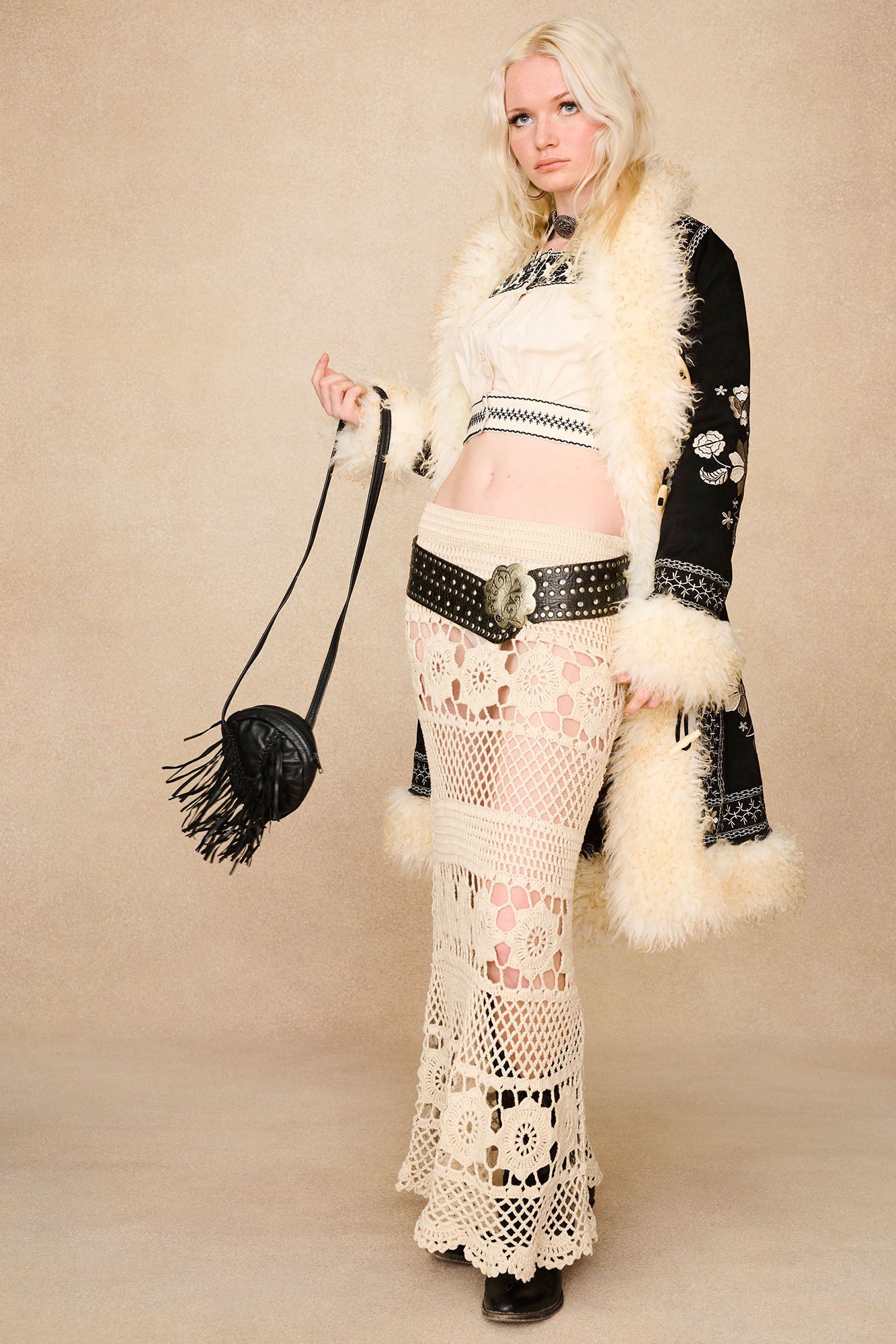 The Hippie Shake's black vintage style afghan coat worn open over our cream embroidered crop top and cream maxi skirt.