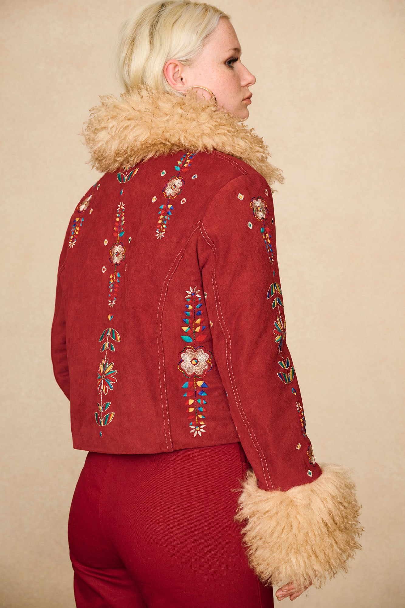 Back view of The Hippie Shake's red embroidered Penny Lane coat showing rear embroidery and shearling cuffs.