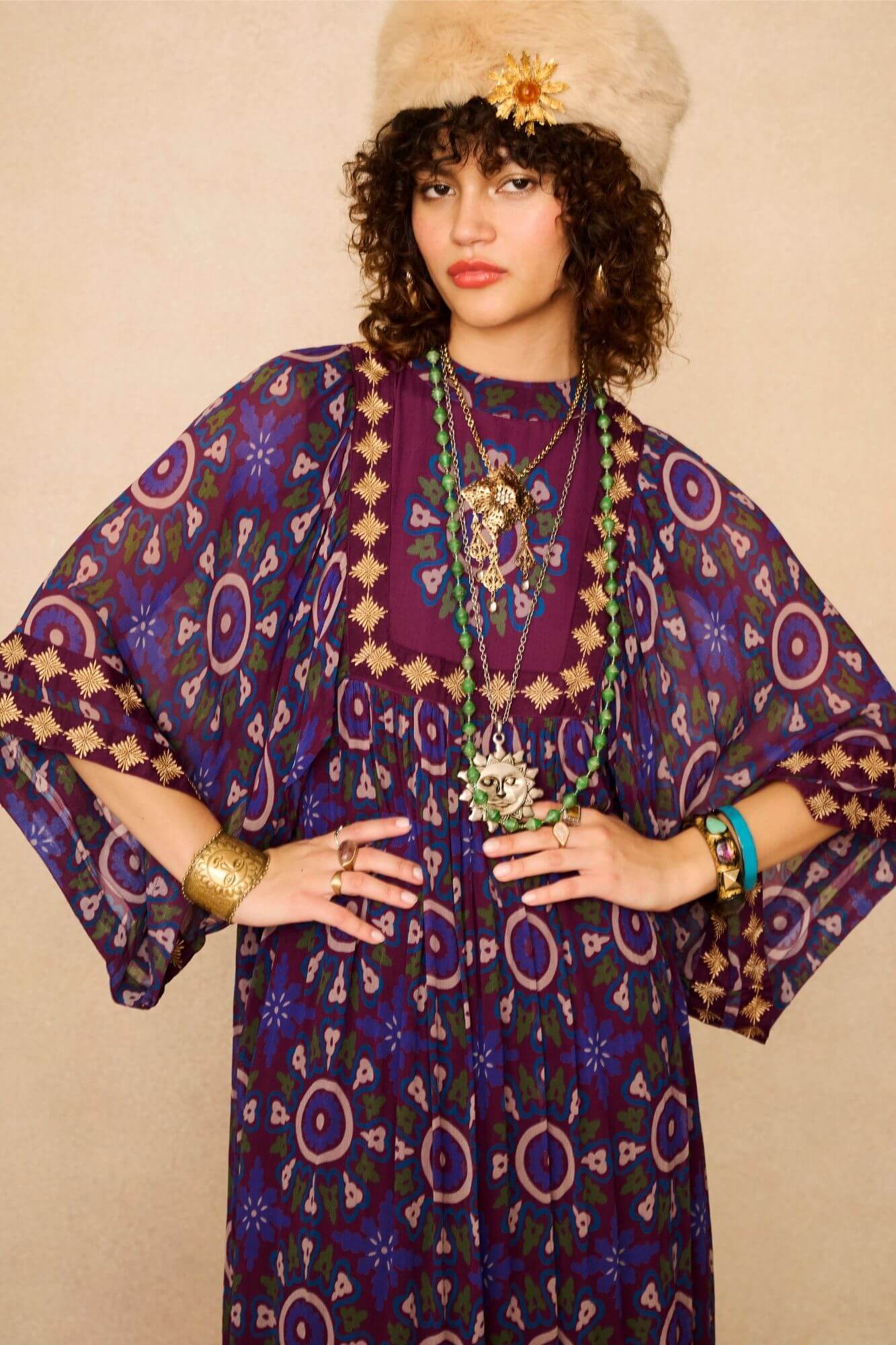 Model wears a 70s style bohemian maxi dress in a printed purple fabric with hand embroidery - close up