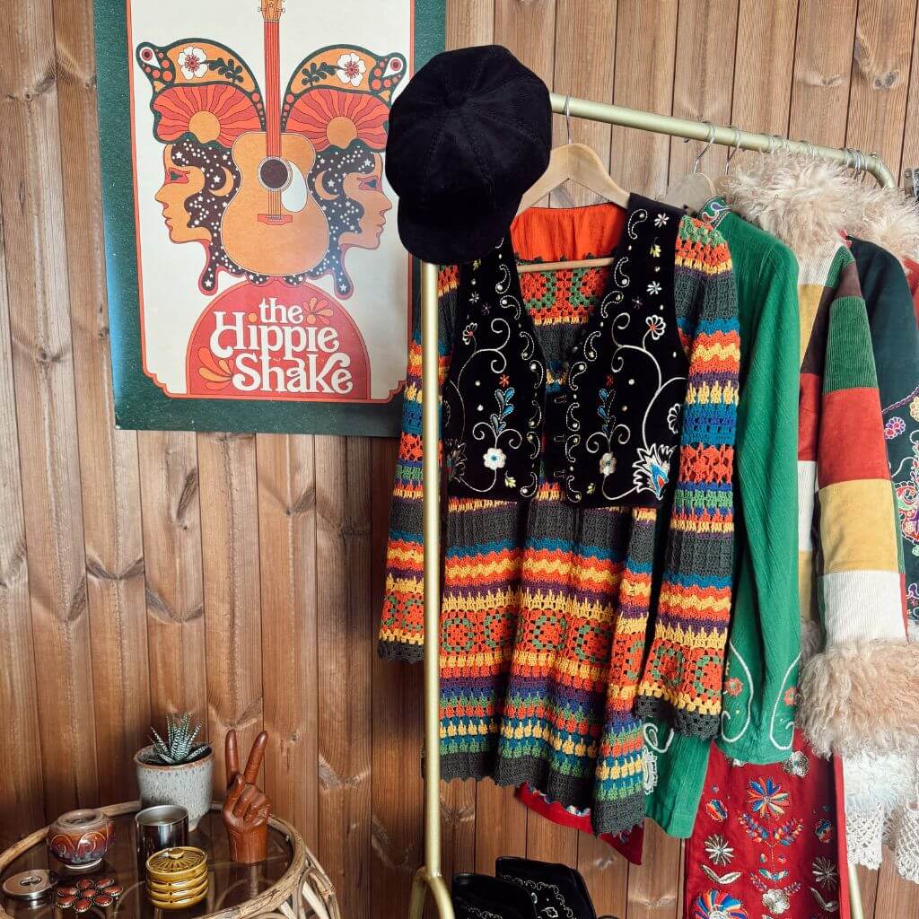 A clothing rack of The Hippie Shake clothing with black Aria vest and knitted dress