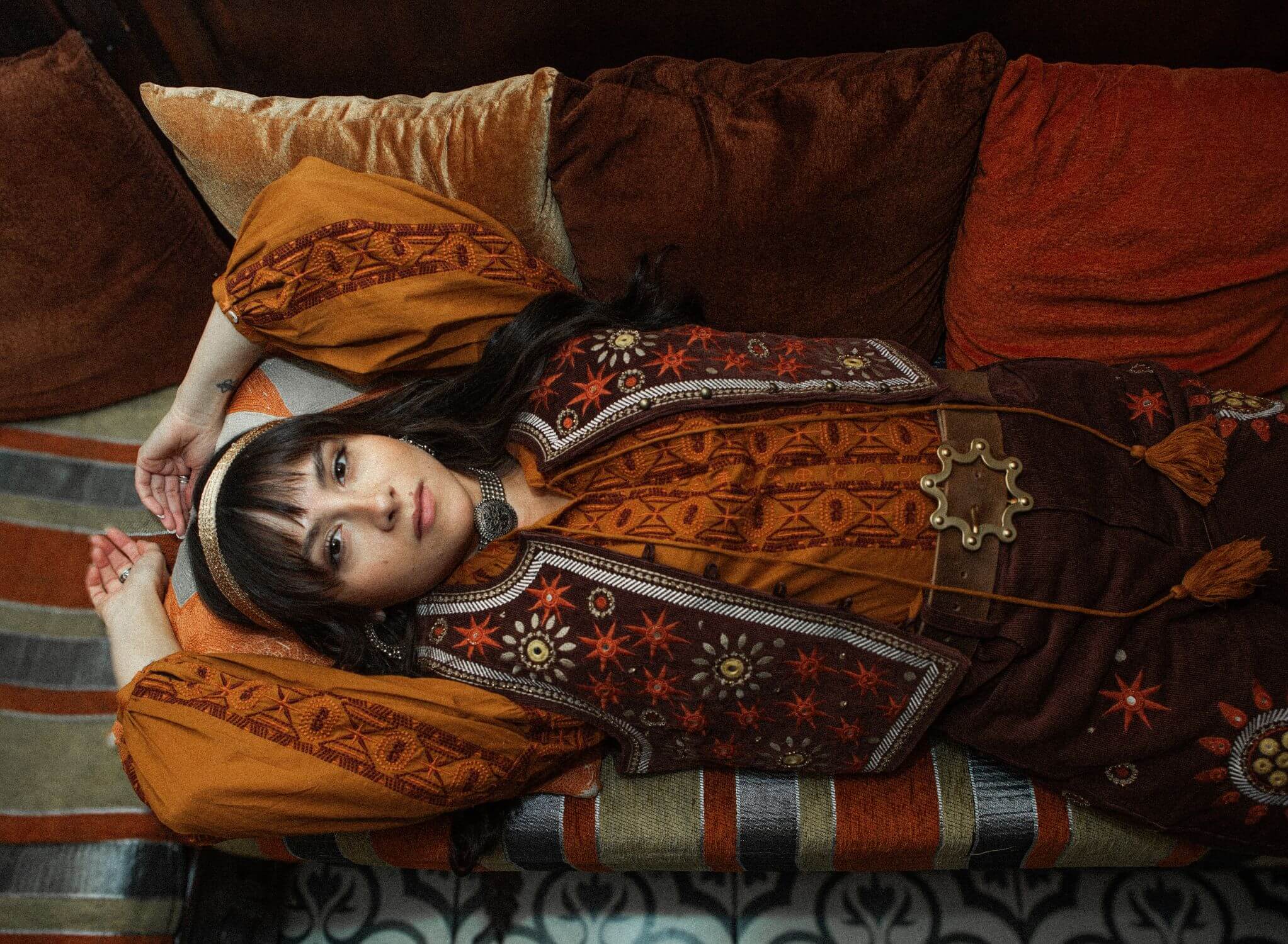 The Hippie Shake House Of The Rising Sun collection - model laying down wearing embroidered blouse and vest