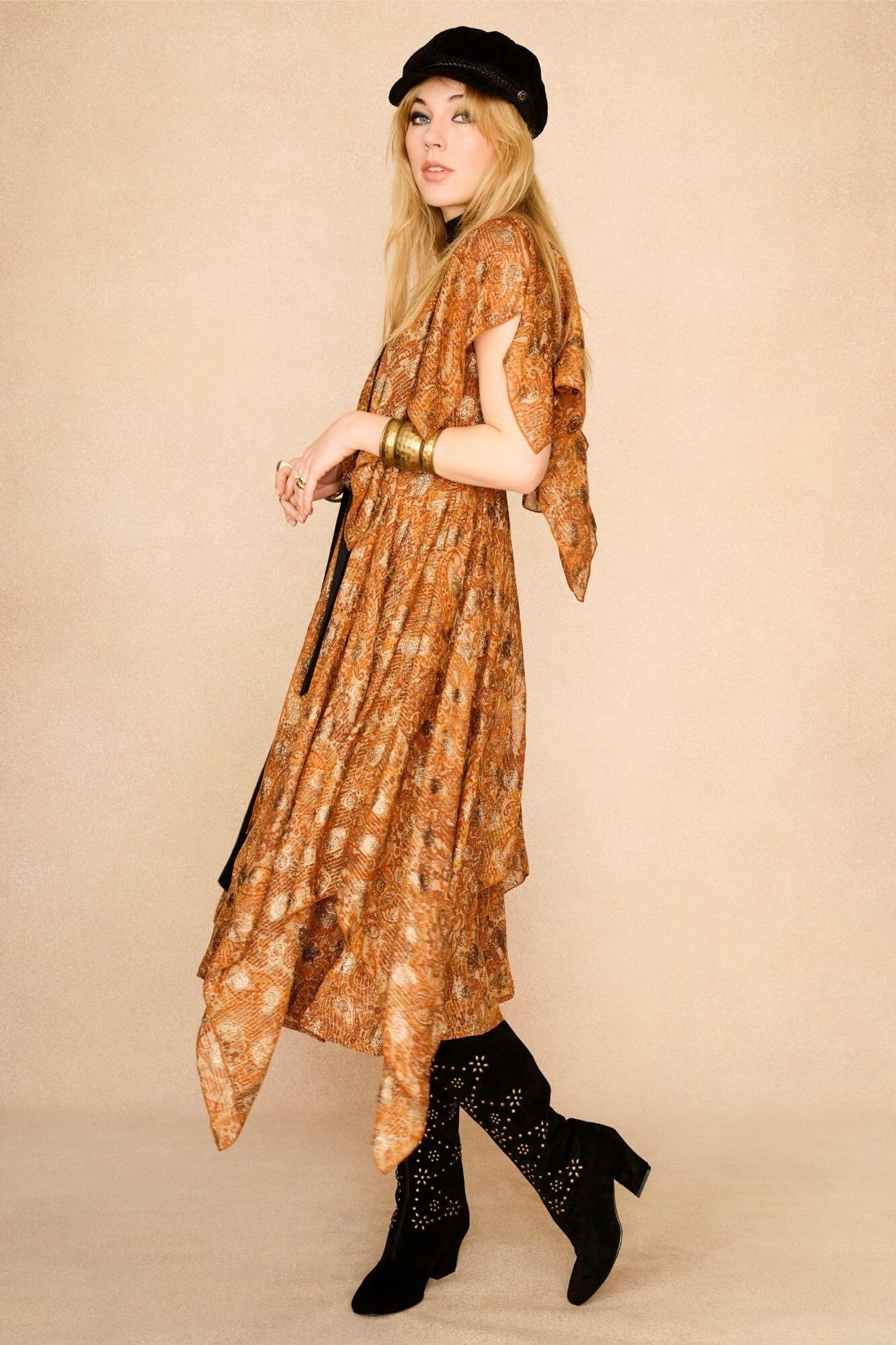 Model wearing a patterned dress and black 70s style suede boots with gold studs
