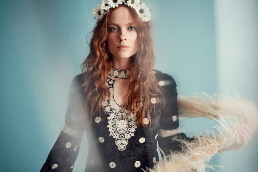 Woman wearing The Hippie Shake black embroidered velvet dress with a floral headband