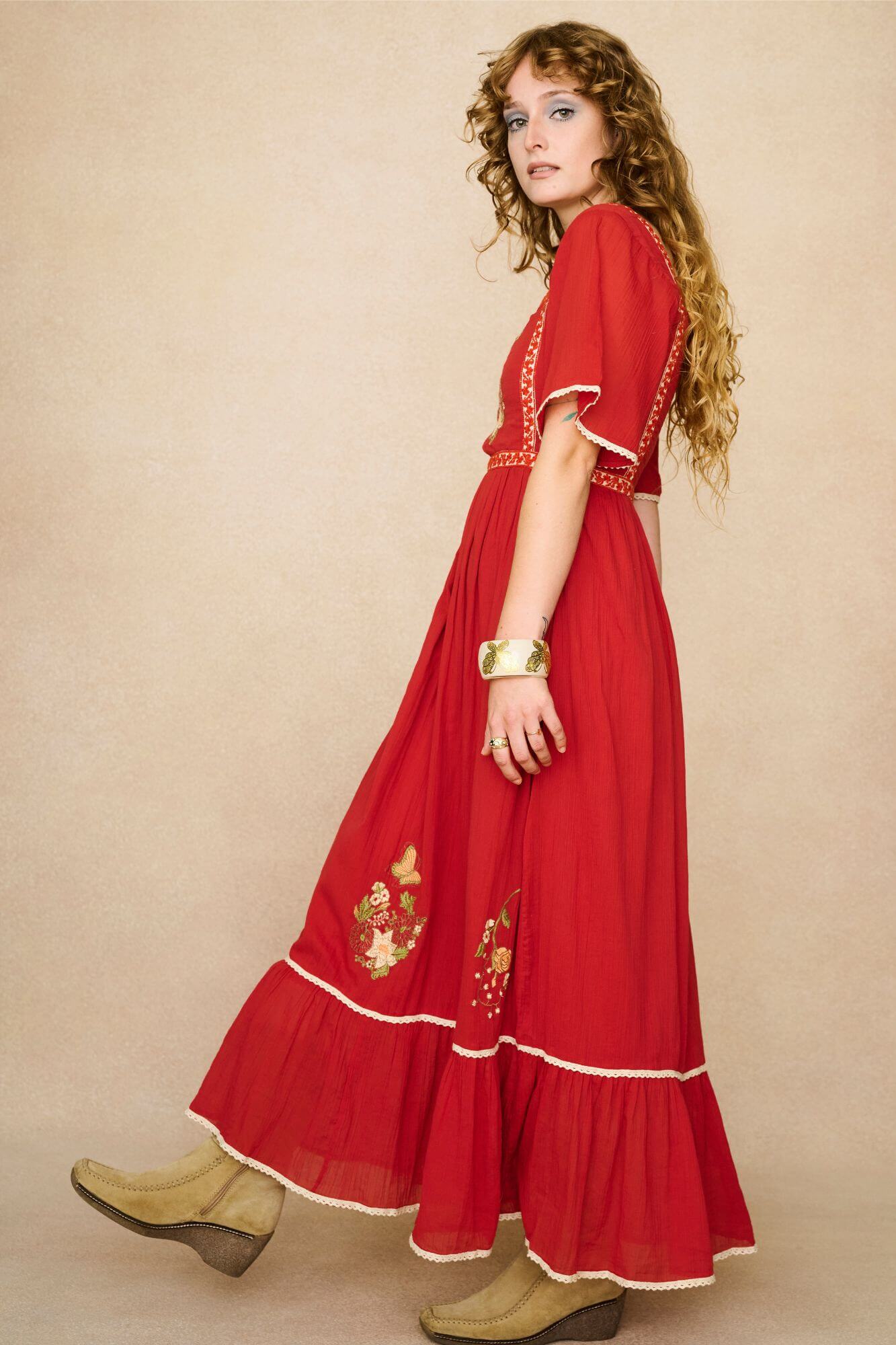 Model wearing a red floaty maxi dress with embroidered details - side view