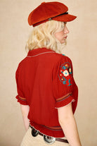 Model wears red floral embroidered Penny Lane blouse in soft cotton with shirred details. A vintage-inspired boho blouse made for everyday and festival styling by The Hippie Shake. Back view