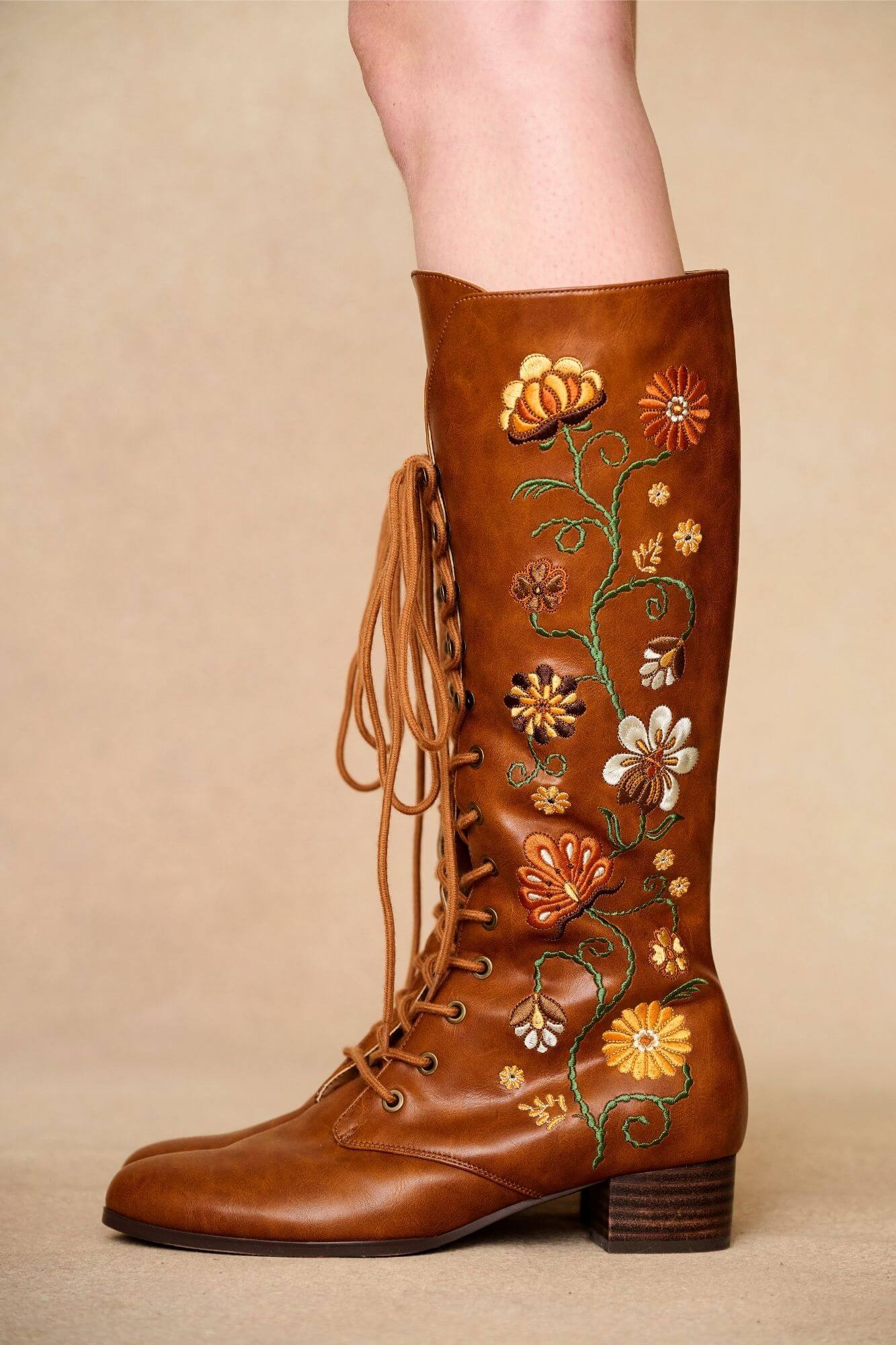 Close up of brown embroidered Penny Lane boots in tan faux leather with lace-up front and block heel. Vintage-inspired boho boots by The Hippie Shake
