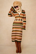 Model wears striped crochet midi dress hand crocheted in cotton with 70s-inspired detailing by The Hippie Shake. Glasses and hat front view