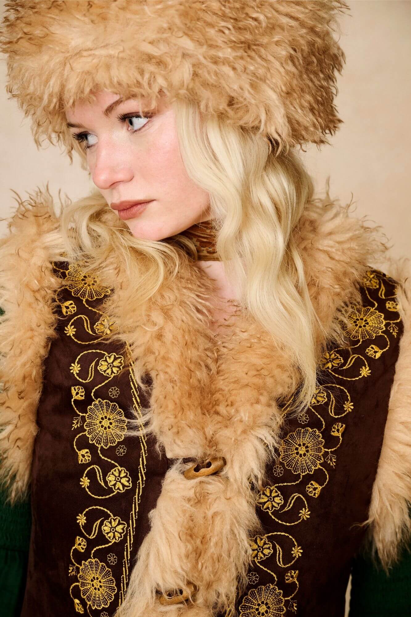 Model wears brown embroidered Penny Lane vest in faux suede with faux fur trim. A 70s-inspired boho layering piece made for vintage and festival styling by The Hippie Shake - close up view