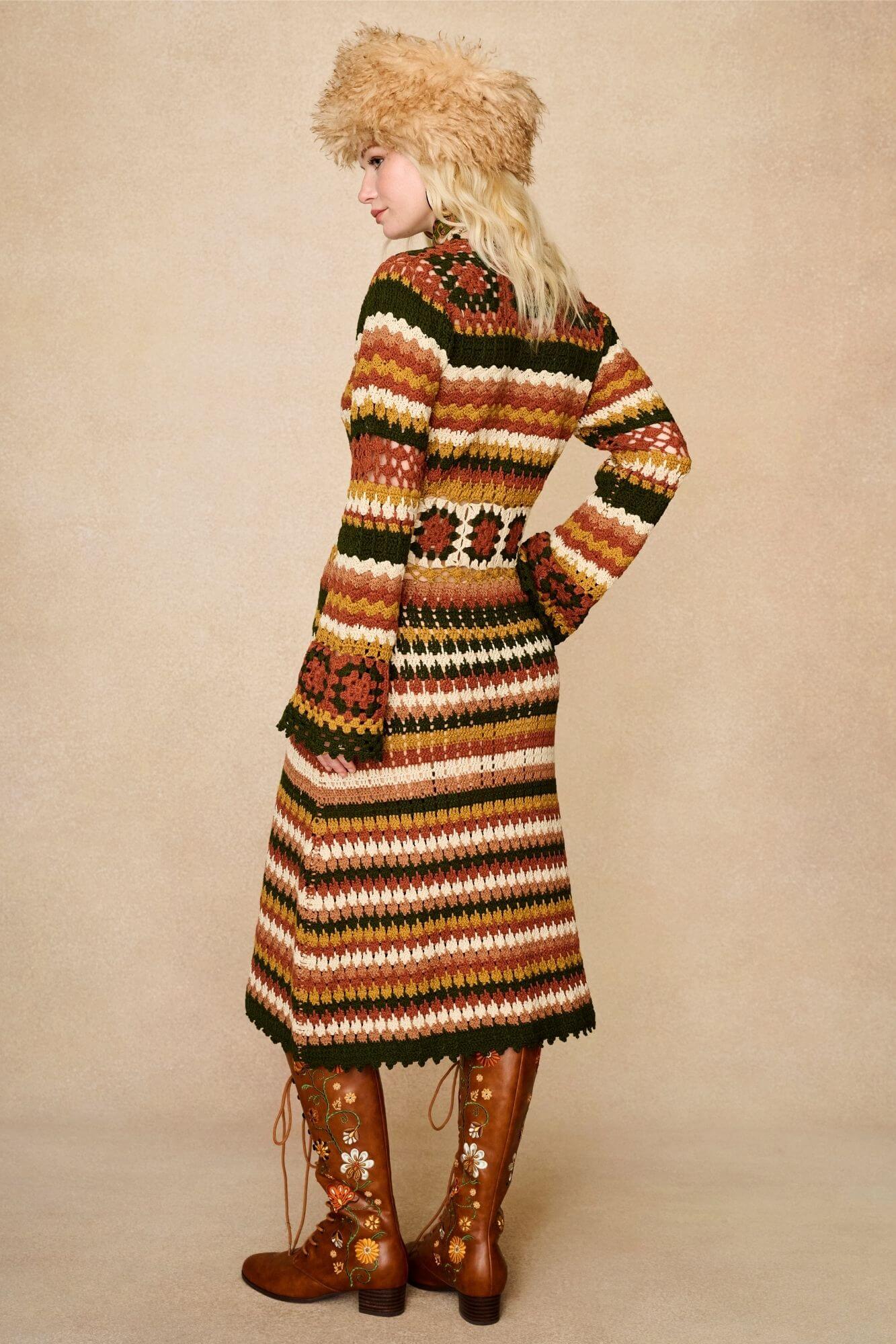 Model wears striped crochet midi dress hand crocheted in cotton with 70s-inspired detailing by The Hippie Shake. Standing back view