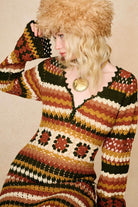 Model wears striped crochet midi dress hand crocheted in cotton with 70s-inspired detailing by The Hippie Shake. Close up with faux fur hat