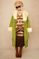 Model wears green embroidered Penny Lane coat in cotton corduroy with faux fur trim. A 70s-inspired statement coat made for bohemian, vintage styling by The Hippie Shake - paired with crochet midi dress