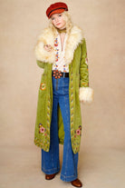 Model wears green embroidered Penny Lane coat in cotton corduroy with faux fur trim. A 70s-inspired statement coat made for bohemian, vintage styling by The Hippie Shake - standing front view