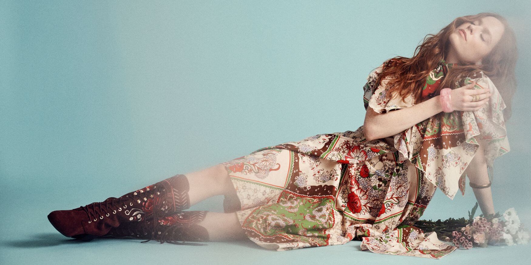 Model sitting in a floral printed hankerchief dress and Penny Lane boots from The Hippie Shake Miss Pamela collection