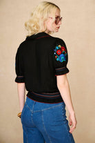 Model wears black floral embroidered blouse in soft cotton with shirred details. A vintage-inspired Penny Lane blouse made for boho, festival and everyday styling by The Hippie Shake - back view