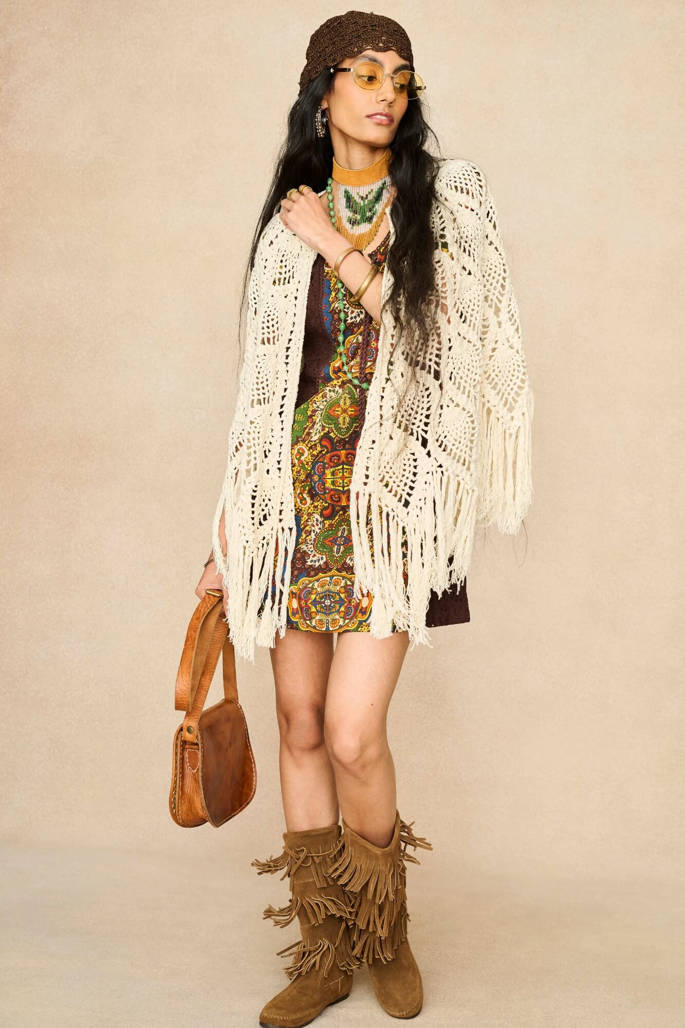 Model wearing cream crochet cape with 70s printed mini dress by The Hippie Shake, front view