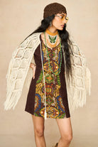 Model wearing cream crochet cape with 70s printed mini dress by The Hippie Shake, front view