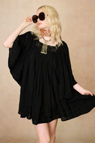 Model wearing 70s black mini dress with lace-up Penny Lane boots by The Hippie Shake, front view
