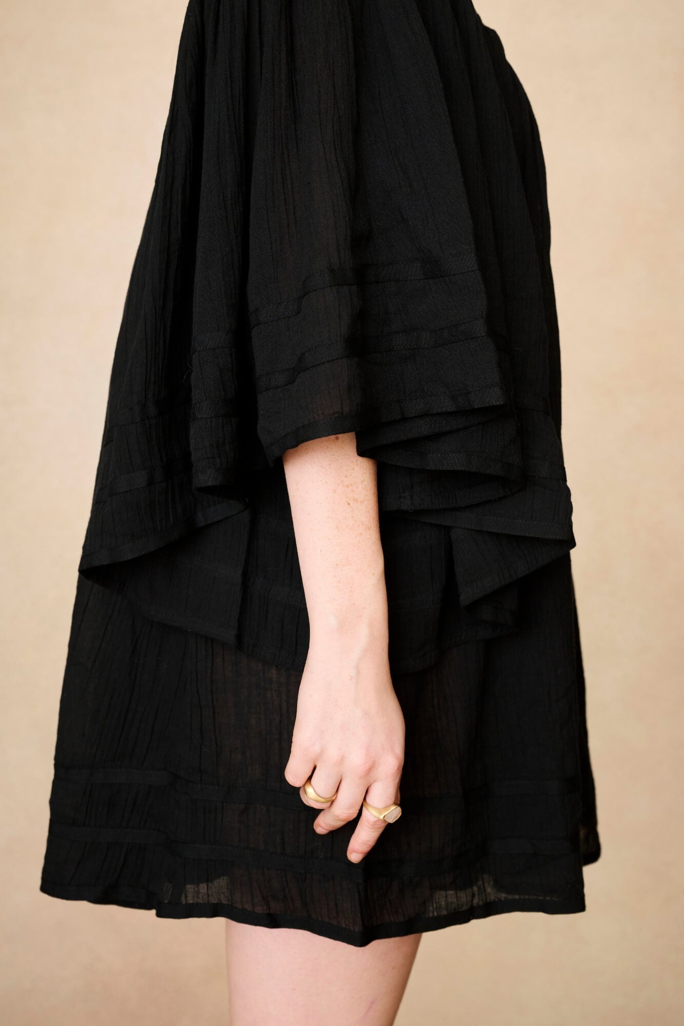 Model wearing 70s black mini dress with lace-up Penny Lane boots by The Hippie Shake, side view