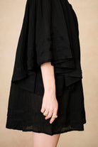 Model wearing 70s black mini dress with lace-up Penny Lane boots by The Hippie Shake, side view