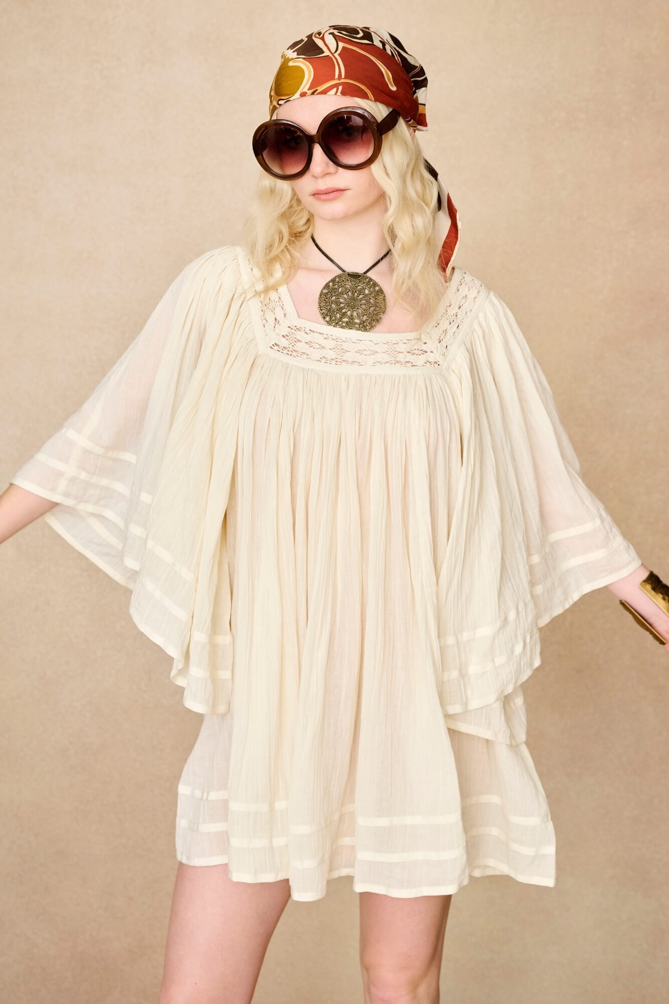 Model wearing 70s cream mini dress with lace-up Penny Lane boots by The Hippie Shake, front view
